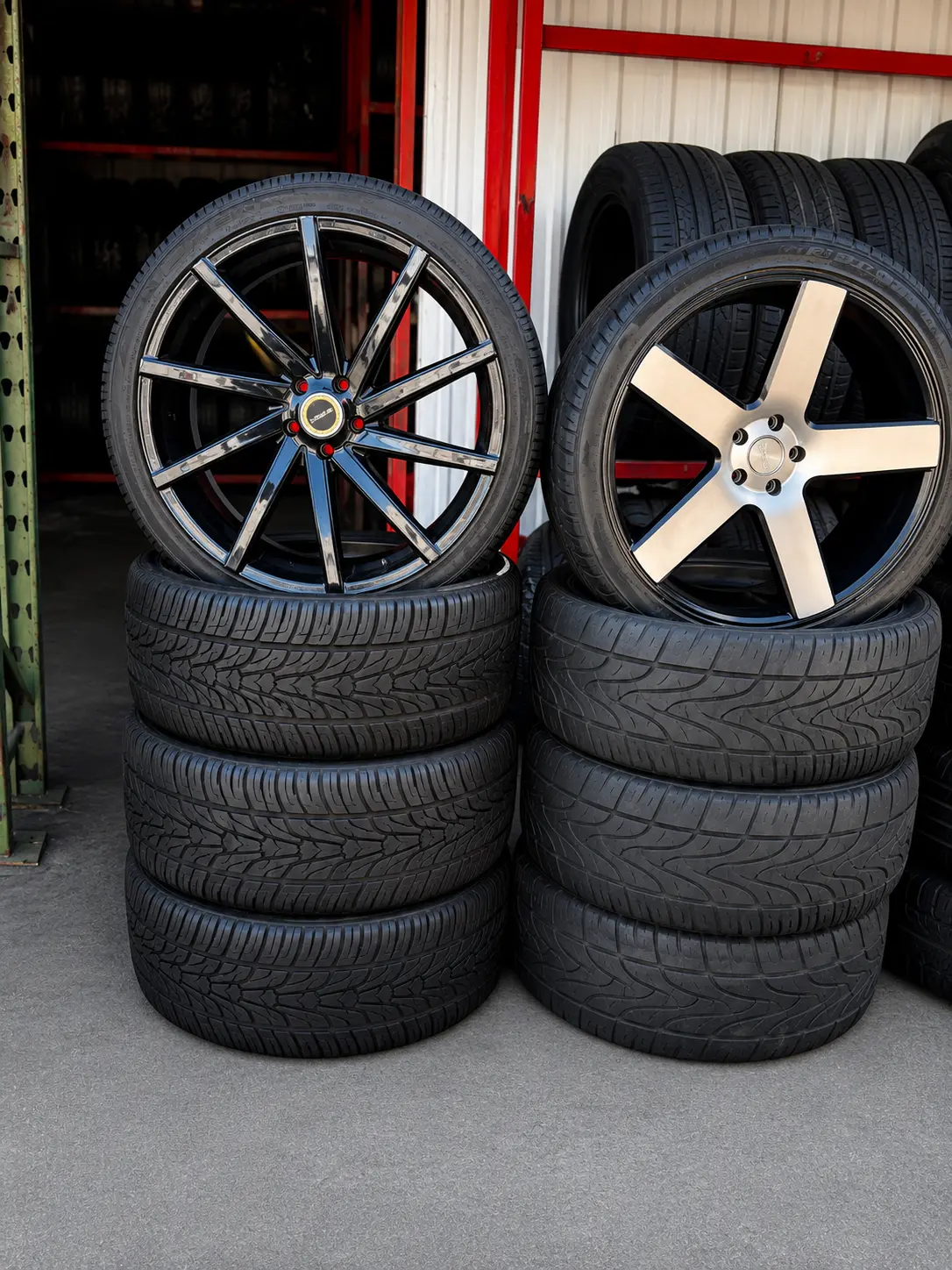 New tires mounted on multi-spoke wheels stacked at the Lopez tire shop